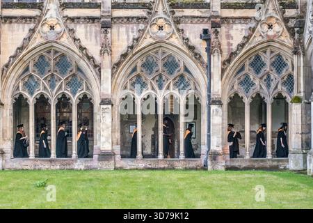 Gli studenti dell'Università del Kent si recano nei chiostri della cattedrale di Canterbury per la cerimonia di laurea alla fine di novembre (Kent, Regno Unito). Tradizionalmente indossano abiti, cappellini o mensa accademica Foto Stock