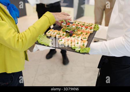 Deliziosi stuzzichini serviti su un piatto durante un evento formale in un locale moderno Foto Stock