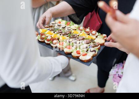 Deliziosi stuzzichini serviti durante un incontro sociale in un elegante ambiente interno Foto Stock