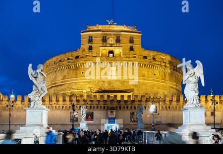 Statue di angeli illuminate di notte sul Ponte Sant'Angelo, con sullo sfondo Castel Sant'Angelo. Roma, Italia. Foto Stock