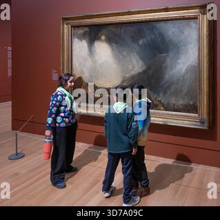 Tate Britain, Londra, Regno Unito. 24 novembre 2025. Turner e Constable: Rivals and Originals (27 novembre 25-12 aprile 26). La prima grande mostra ad esplorare le vite intrecciate e le eredità dei più venerati artisti paesaggisti britannici: JMW Turner (1775-1851) e John Constable (1776-1837). Pittori radicalmente diversi, ognuno sfidava le convenzioni artistiche del tempo, sviluppando modi di immaginare il mondo che ancora oggi risuonano. Immagine: I bambini guardano la tempesta di neve di JMW Turner: Hannibal e il suo esercito che attraversano le Alpi. Collezione Tate. Crediti: Malcolm Park/Alamy Live News Foto Stock