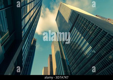 Le enormi torri di vetro che fiancheggiano la Sixth Avenue, conosciuta anche come Avenue of the Americas, nel cuore di Midtown Manhattan. Foto Stock