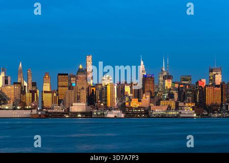 Una splendida vista panoramica dello skyline di Midtown Manhattan vista dal lungomare di Weehawken attraverso il fiume Hudson. Foto Stock