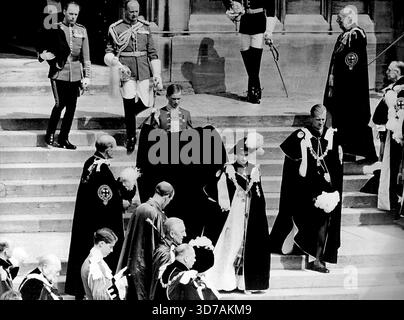 Churchill si insediò come Cavaliere della Giarrettiera -- la Regina, indossando per la prima volta il suo mantello di Kingfisher blu, un cappello tudor piatto di velluto nero, e il collare d'oro dell'ordine, lascia la Cappella di San Giorgio dopo la cerimonia. Al suo fianco c'è il duca di Edimburgo. Sir Winston Churchill e' in basso a sinistra, allineando i gradini con altri membri dell'ordine in onore di sua Maesta'. Gli altri mostrati non sono identificati. La regina Elisabetta oggi 14 giugno installò Sir Winston Churchill, il Premier britannico, nell'ordine della Giarrettiera antica e illustre degli ordini cavallereschi britannici, in una cerimonia a S. Foto Stock