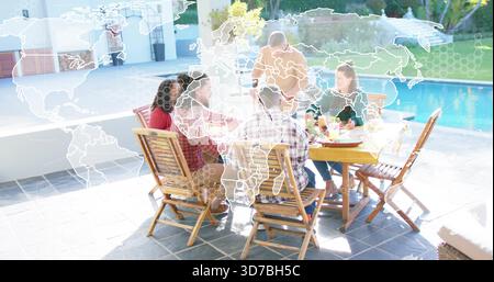 Riunire sei adulti intorno a un tavolo di legno che condivide il pasto sul patio piastrellato accanto alla piscina, con la mappa del mondo sovrapposta Foto Stock