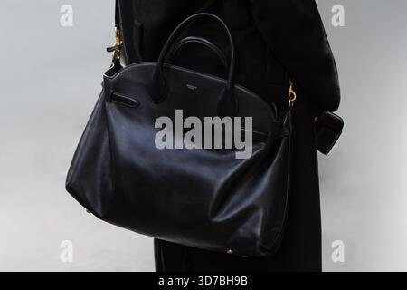 Parigi, Francia - 4 ottobre 2025: Donna indossa una borsa a spalla Coach nera. Look Street style Foto Stock