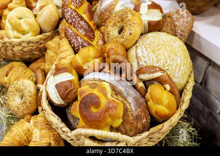 Il pane artigianale di diverse forme è disposto in cesti decorativi presso la panetteria locale. Foto Stock