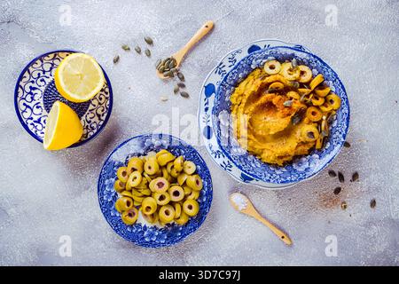 Delizioso humus di zucca o immersione con olive verdi Foto Stock