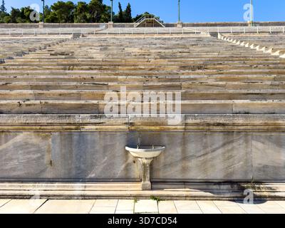 Posti a sedere in marmo allo Stadio Panatenaico di Atene sotto la chiara luce di mezzogiorno, vista dal basso Foto Stock
