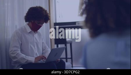 Lavoratore che indossa una camicia bianca che scrive sul laptop alla finestra con maschera rossa e spazio per copiare Foto Stock