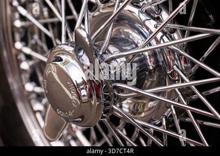 Foto macro dettagliata della ruota metallica cromata lucida di un'auto d'epoca, che mostra le intricate razze e la superficie metallica riflettente. Foto Stock