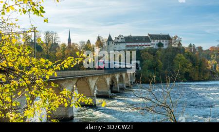Paesaggio autunnale delle Cascate del Reno. Treno che attraversa il ponte Rheinbruecke bei Laufen. Schaffhausen, Svizzera. Foto Stock