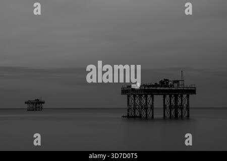 Lunga esposizione in bianco e nero di piattaforme di raffreddamento offshore abbandonate a Sizewell Foto Stock