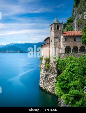 Veduta verticale dell'Eremo di Santa Caterina del Sasso, un monastero aggrappato alla scogliera rocciosa del Lago maggiore. Esposizione lunga. Leggiuno, Varese Foto Stock