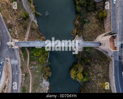 Vista aerea dell'antico ponte di San Martin che si estende sulle acque scure del fiume Tago, Toledo, Castiglia-la Mancha, Spagna. Foto Stock
