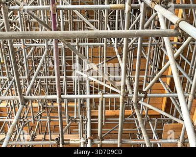 Complicata rete di pali per impalcature all'interno di un edificio per la ristrutturazione della struttura. Niente persone. Foto Stock
