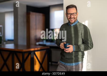 Ritratto di un uomo felice di successo equilibrato che ride, gode delle piccole cose della vita. Beve caffè Foto Stock