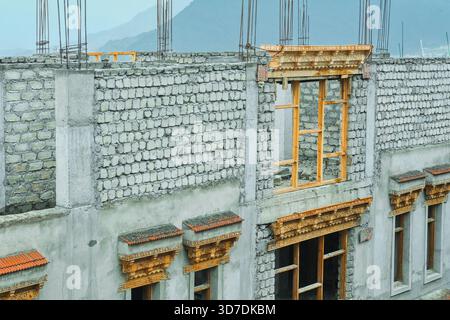 Facciata di una tradizionale casa tibetana in costruzione con finestre in legno nella città di Leh, Ladakh, Himalaya, India settentrionale Foto Stock