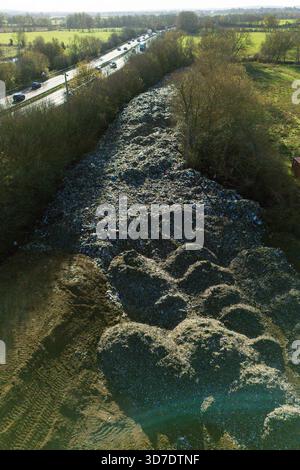 Una vista generale della montagna di rifiuti lunga 150 m che è stata scaricata illegalmente accanto alla A34 e vicino al fiume Cherwell a Kidlington, Oxfordshire. Data foto: Martedì 25 novembre 2025. Foto Stock
