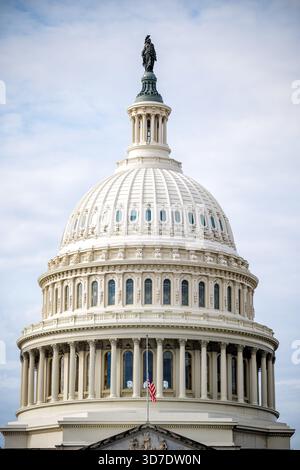 United States Capitol Building Dome Washington DC / WASHINGTON DC - la cupola del Campidoglio degli Stati Uniti è coronata dalla Statua della libertà in bronzo. Progettata da Thomas U. Walter e completata nel 1866, la cupola in ghisa si innalza per circa 87 metri (288 piedi) in cima alla statua. La Statua della libertà alta 5,9 metri, scolpita da Thomas Crawford, fu collocata nel 1863. Una bandiera americana vola a mezz'asta di fronte alla cupola, a indicare il lutto nazionale. Il Campidoglio è la sede legislativa del governo federale degli Stati Uniti, che ospita il Congresso degli Stati Uniti. Foto Stock