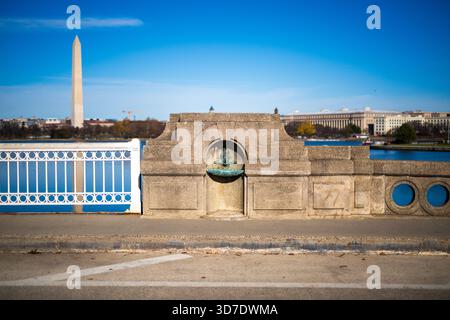 WASHINGTON DC - le fontane dei pesci del Ponte dell'Inlet presso il bacino delle Tidal sono stravaganti sculture in bronzo create da Costantino Seferlis nel 1987. Queste caratteristiche uniche rendono omaggio a Manus "Jack" Fish, ex direttore regionale del National Park Service. Fish supervisionò importanti progetti di Washington DC, tra cui Constitution Gardens e Vietnam Veterans Memorial, prima del suo ritiro. Le sculture, che sostituirono le originali fontane di bronzo, fondono le caratteristiche di Fish con un corpo simile a un pesce, un giocoso richiamo al suo nome e alla sua eredità. Foto Stock