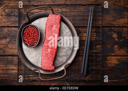 Bistecca di manzo wagyu marmorizzata di alta qualità, pronta per essere trasformata in un capolavoro gourmet. Una scelta deliziosa per il palato di qualsiasi amante della carne. dorso di legno Foto Stock