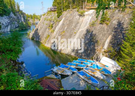 Diverse barche da diporto si sono allineate su un molo vicino a un lago. Foto Stock