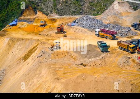 Vista aerea direttamente sopra un dumper industriale o un veicolo in movimento terra con terreno fangoso e tracce di pneumatici nel settore edile su un brownfi Foto Stock