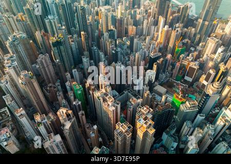 Una prospettiva dall'alto verso il basso su Hong Kong rivela l'incredibile densità dei suoi alti edifici. La luce del sole scorre attraverso le torri, evidenziando il Foto Stock