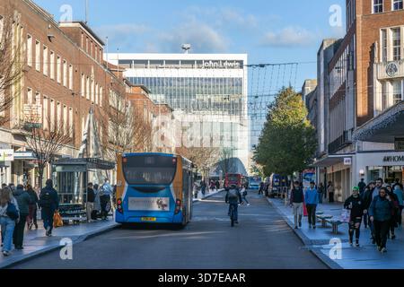 Autobus e amanti dello shopping, strada trafficata del centro città a Christmas, High Street, Exeter, Devon, Inghilterra, REGNO UNITO Foto Stock