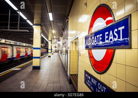 LONDRA - 29 OTTOBRE 2025: Stazione della metropolitana Aldgate East - binario in direzione est District & Hammersmith & City Line con treno in partenza Foto Stock
