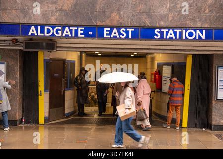 LONDRA - 29 OTTOBRE 2025: Aldgate East Station E1 - pendolari in giornata di pioggia con i classici Roundels della metropolitana di Londra Foto Stock