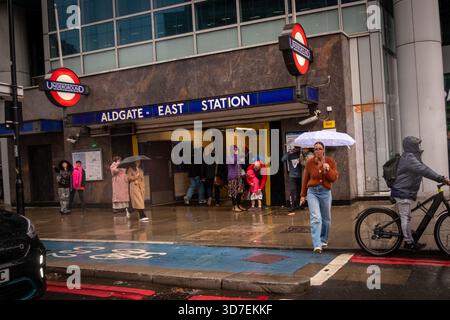 LONDRA - 29 OTTOBRE 2025: Aldgate East Station - iconica stazione della metropolitana di Londra e pendolari sotto la pioggia Foto Stock