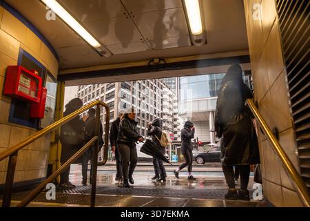 LONDRA - 29 OTTOBRE 2025: Aldgate East Station - iconica stazione della metropolitana di Londra e pendolari sotto la pioggia Foto Stock
