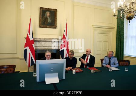 Il primo ministro Sir Keir Starmer siede con il ministro degli Esteri Yvette Cooper, il segretario alla difesa John Healey e il capo di stato maggiore della difesa Richard Knighton mentre copresiede una chiamata virtuale con i membri della Coalizione dei volenti, i paesi pronti a offrire sostegno all'Ucraina mentre gli sforzi continuavano a trovare un accordo di pace per porre fine alla guerra con la Russia di Vladimir Putin. Data foto: Martedì 25 novembre 2025. Foto Stock