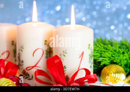 Saluti per la seconda domenica di Avvento: Due candele accese dell'Avvento con decorazioni natalizie Foto Stock