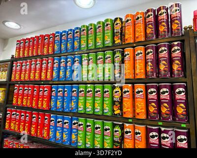 Una vivace esposizione di contenitori di patate Pringles disposti ordinatamente sugli scaffali di un negozio di alimentari. Sharm El Sheikh, Egitto - 24.11.2025 Foto Stock