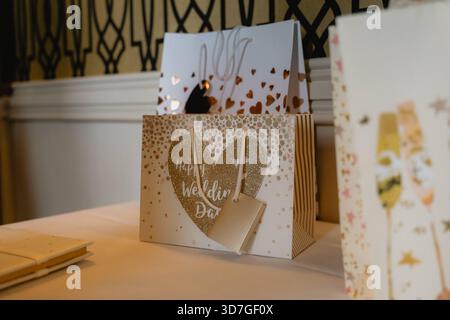 Una borsa bianca con un cuore sopra e le parole Happy Wedding scritte sopra. La borsa è seduta su un tavolo Foto Stock