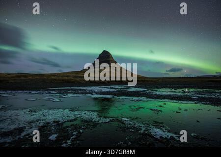 Kirkjufell sotto una forte aurora Foto Stock