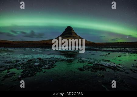 Kirkjufell sotto una forte aurora Foto Stock
