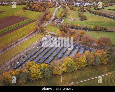 Impianto solare su larga scala vicino a un villaggio, circondato da campi autunnali, Bau PV Freifaechenanlage, Weil der Stadt, Germania Foto Stock