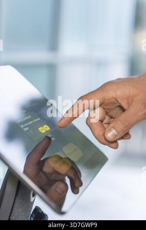 Primo piano di una mano che tocca un touchscreen con display riflettente, Roboloutions robotici nel museo della gioielleria di Pforzheim, Germania Foto Stock