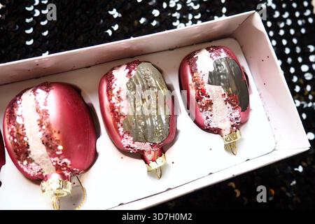 Decorazioni rotte dell'albero di Natale in vetro, palline di Natale sotto forma di torte - pasta in una scatola. Delusione per la distruzione dei prodotti in vetro per Natale Foto Stock