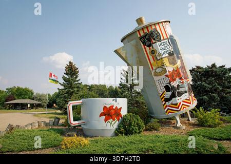 Caffettiera gigante inclinata su una tazza in un'area picnic a Davidson, Saskatchewan, Canada. La pentola è alta 24 piedi e può contenere 150.000 tazze. Foto Stock