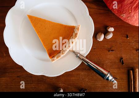 Una fetta di torta di zucca servita su un piatto bianco Foto Stock