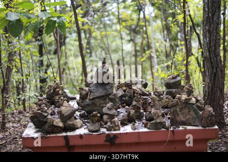 Un cairn spirituale di pietra impilata in un tranquillo ambiente forestale. Scultura d'arte naturale che rappresenta equilibrio, zen, meditazione e scena tranquilla di harmon Foto Stock