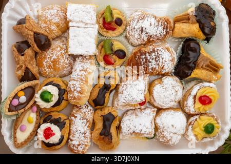 Varietà di dolci italiani dolci dolci dolci dolci dolci e torte con panna e frutta su piatto realizzati in panetteria artigianale a Roma, Italia, primo piano Foto Stock
