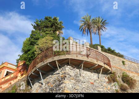 Punto panoramico sulla torre medievale in pietra. Natura e strutture del Mediterraneo e dell'Europa. Cielo e palme. Sfondo per il design. Turismo e. Foto Stock