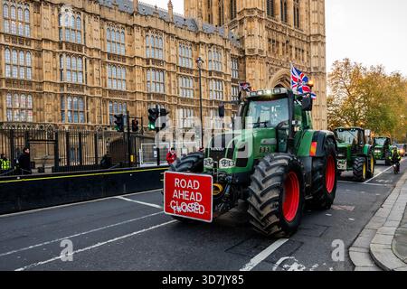 Londra, Regno Unito. 26 novembre 2025. La polizia ferma i trattori giù per whitehall, quindi parcheggiano o si dirigono intorno a Parliament Square (dove devono passare davanti ai sostenitori pro-UE rimangono sostenitori - nel giorno del budget gli agricoltori protestano con i loro trattori vicino al Parlamento di Londra. Gli agricoltori continuano a protestare contro la decisione di Rachel Reeves di imporre l'imposta sull'eredità (IHT) su tutte le aziende agricole, per un valore di oltre 1 milione di sterline, che ritengono "abbia messo gli agricoltori britannici in una posizione pericolosa”. Crediti: Guy Bell/Alamy Live News Foto Stock