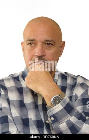 Uomo calvo che poggia il mento sulla mano in una posa ponderata su uno sfondo neutrale. Foto Stock